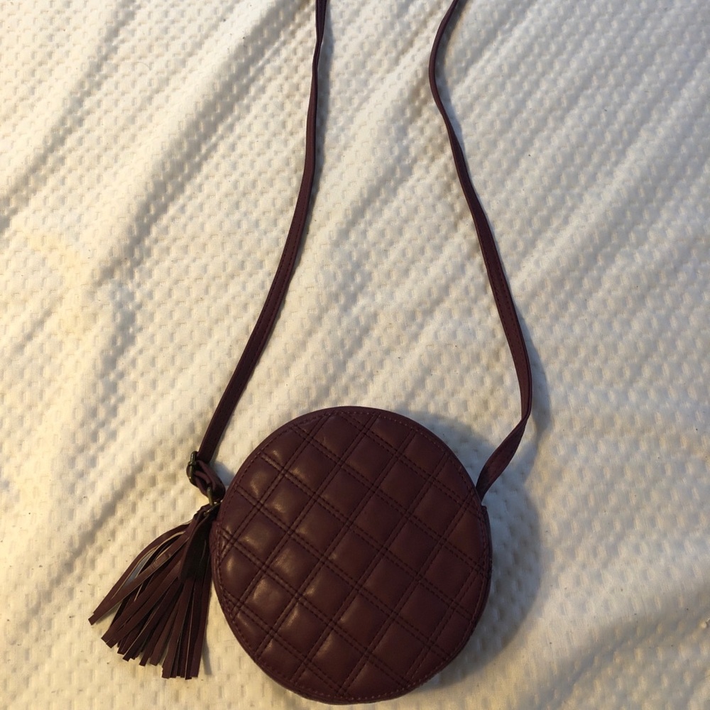 Small round burgundy over the shoulder bag with a little tassel